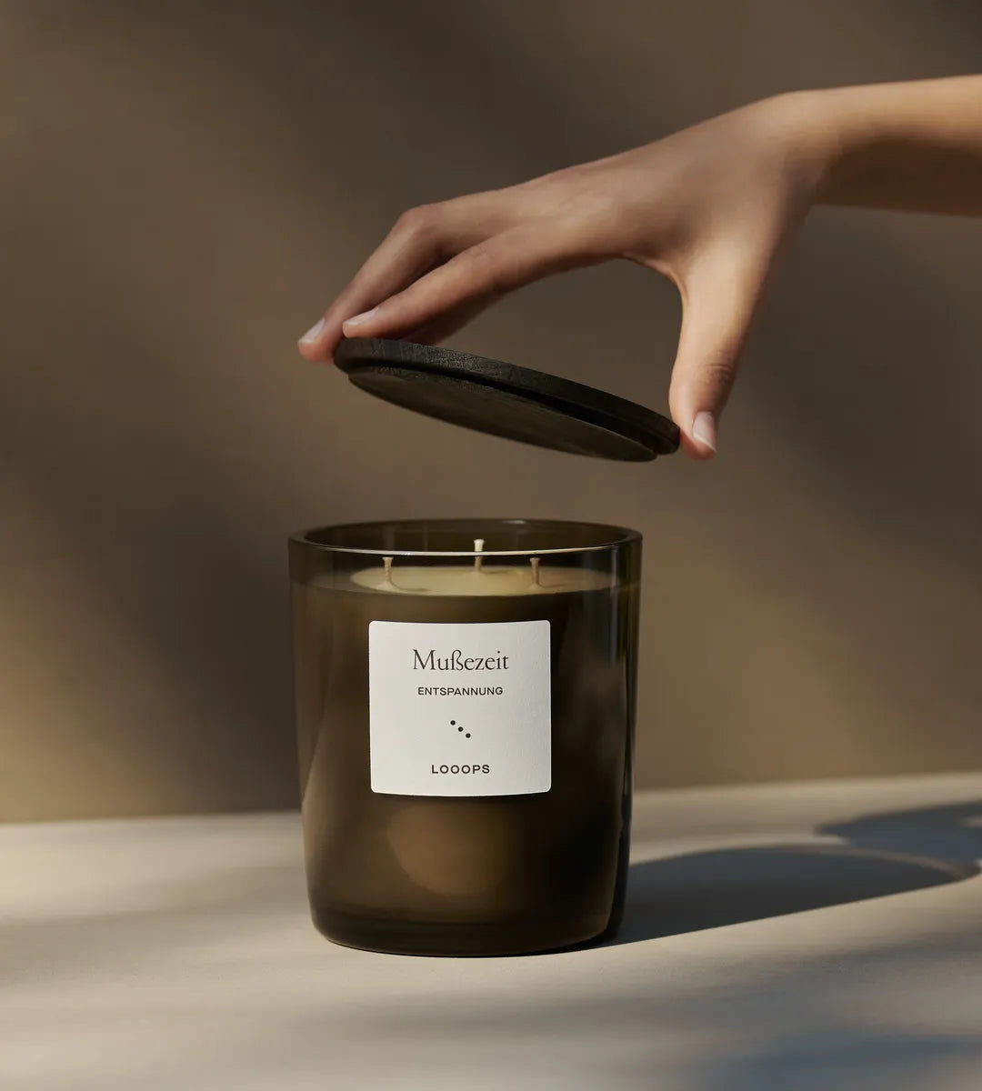 Von Dreidochtkerze wird Deckel angehoben