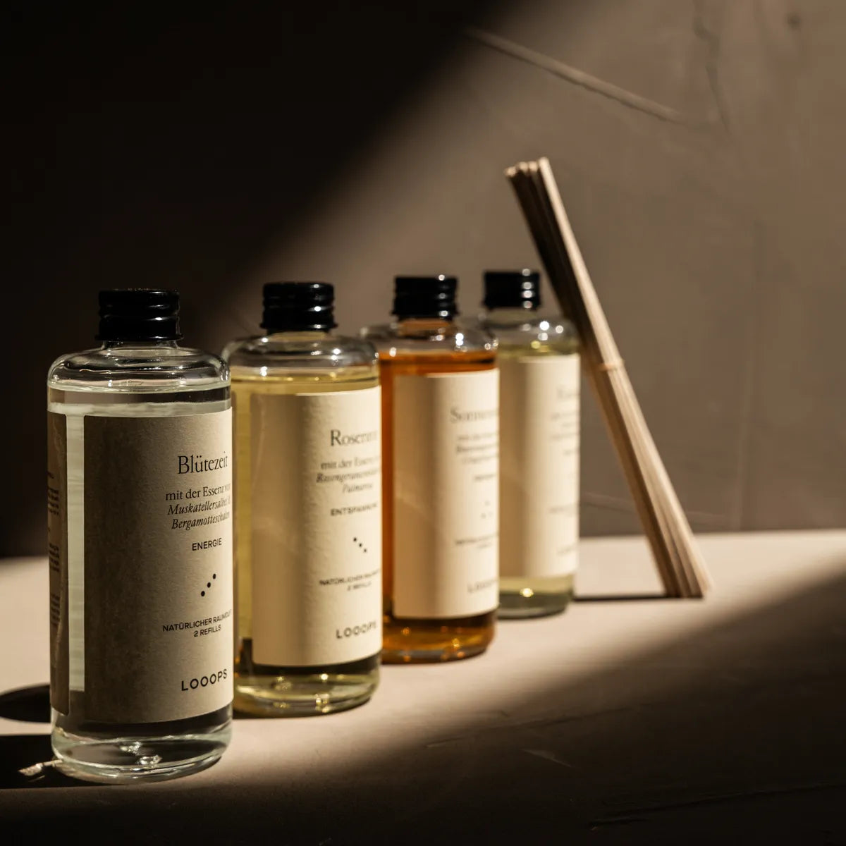 Glass bottles next to each other and paper sticks in the background