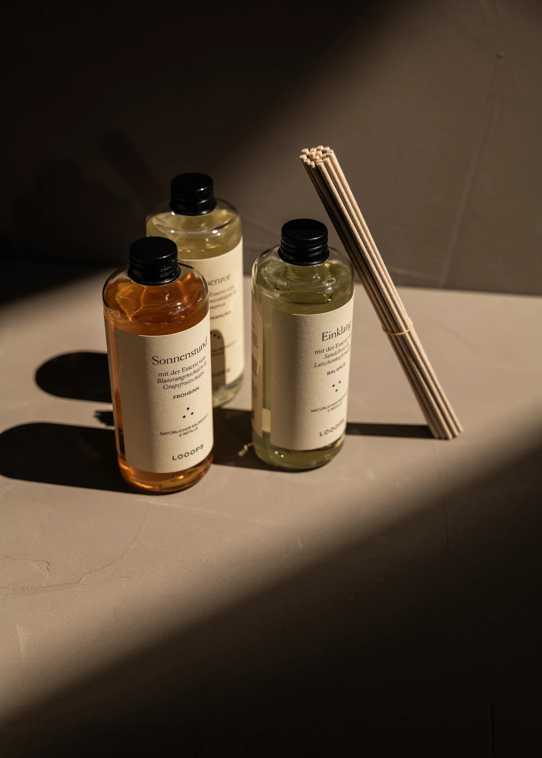 Three glass bottles and paper sticks are ajar