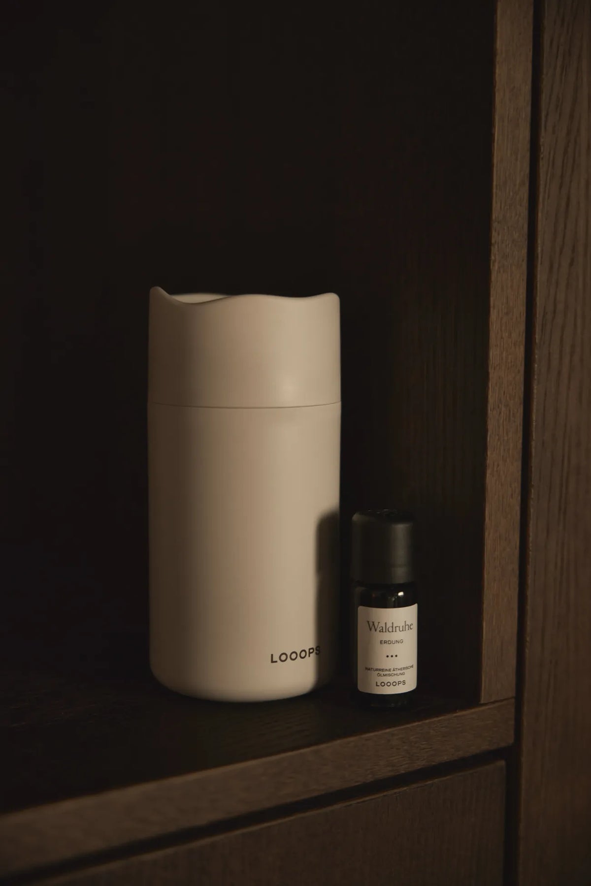 Looops 's Aeris Aroma Diffuser with essential oil on a wooden dresser