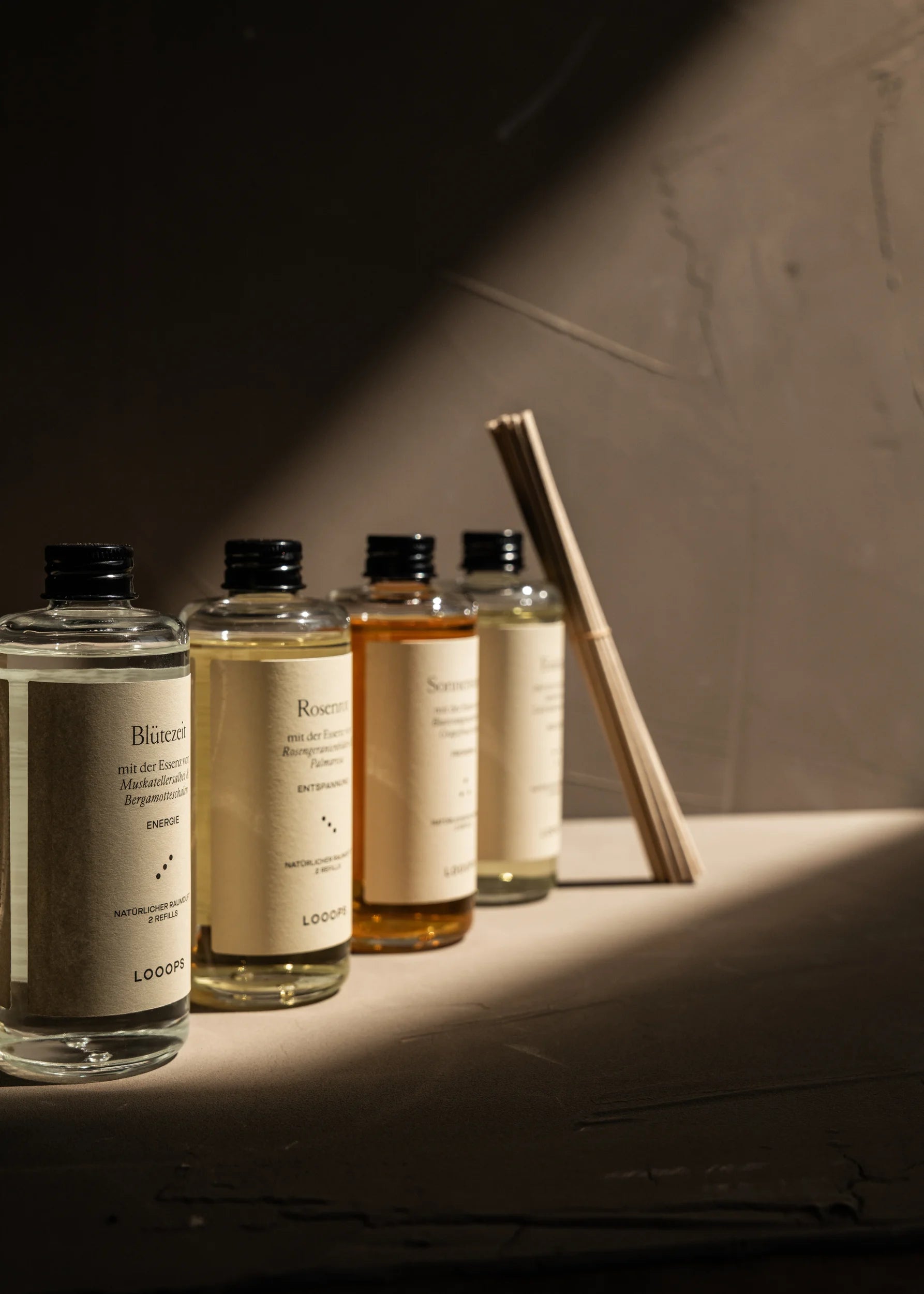 Glass bottles next to each other, paper sticks in the background