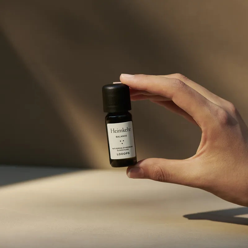 An essential oil is held by a hand.