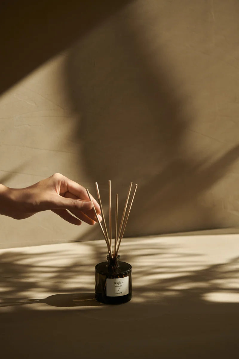 Scent sticks are touched by one hand. 